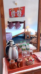 una camera con letto e bollitore per il tè su un tavolo di The Comfort a Kandy