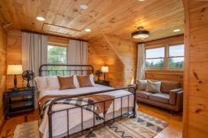 1 dormitorio en una cabaña de madera con 1 cama y 1 sofá en Alpine Ridge, en Banner Elk