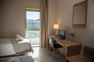 a hotel room with a desk with a computer and a window at Hotel La Parada in Getafe