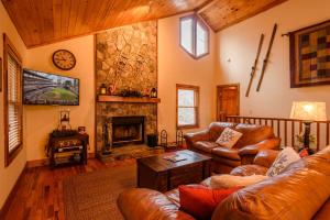 a living room with leather furniture and a fireplace at Appalachian Breeze in Blowing Rock