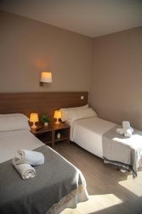 pokój hotelowy z dwoma łóżkami i ręcznikami na nich w obiekcie Hotel La Parada w mieście Getafe