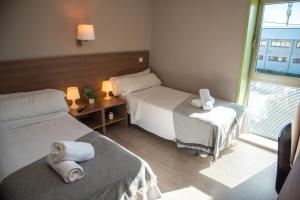 pokój hotelowy z dwoma łóżkami i oknem w obiekcie Hotel La Parada w mieście Getafe