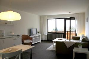 eine Küche und ein Wohnzimmer mit einem Sofa und einem Tisch in der Unterkunft Kastanienhof Apartment und Restaurant in Dannenfels