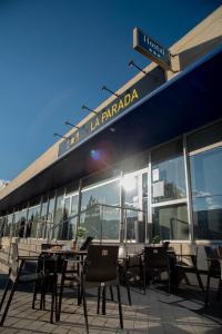 restauracja ze stołami i krzesłami przed budynkiem w obiekcie Hotel La Parada w mieście Getafe