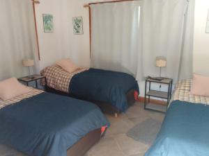 Habitación con 2 camas y 2 mesas con lámparas en La Pirámide en San Carlos de Bariloche