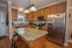 a kitchen with a stainless steel refrigerator and wooden cabinets at Bear Necessities in Beech Mountain