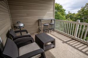 a porch with chairs and a table and a stool at Bear Necessities in Beech Mountain