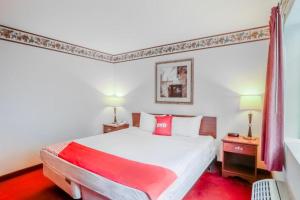 a bedroom with a large white bed with red pillows at OYO Hotel Olympia - Tumwater in Tumwater