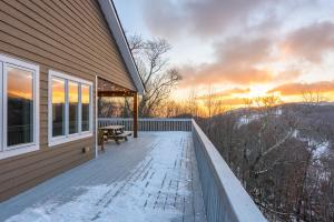 a house with a deck with a table and a bench at Bear The View in Seven Devils