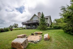 une grande maison avec des rochers dans la cour dans l'établissement Bald Eagle Bluff, à Blowing Rock