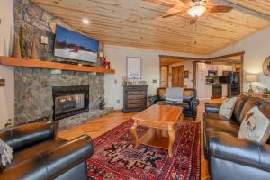 a living room with leather furniture and a stone fireplace at Bear The View in Seven Devils