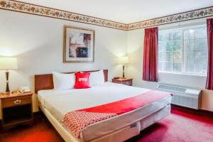 a bedroom with a large bed with red pillows at OYO Hotel Olympia - Tumwater in Tumwater