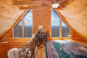 una oficina en una cabaña de madera con ventilador de techo y ventanas en Beech View Retreat, en Zionville