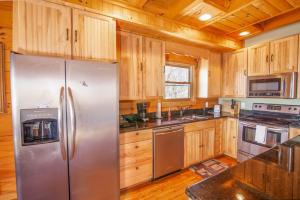 a kitchen with a stainless steel refrigerator and wooden cabinets at Beech View Retreat in Zionville +23 photos