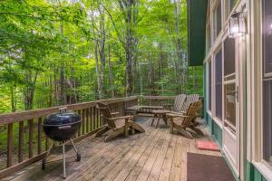 a screened in porch with chairs and a grill at Benzine Farm in Beech Mountain