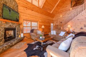 un soggiorno con camino in una baita di tronchi di Big Bear Cabin a Banner Elk