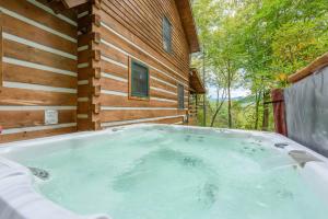 a jacuzzi tub outside of a wooden house at Big Timber Creek Cabin in Sugar Grove