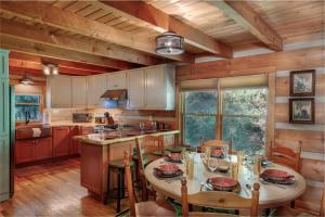 een keuken met een tafel met stoelen en een groot raam bij Big Timber Creek Cabin in Sugar Grove