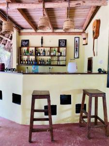 two wooden stools sitting in front of a bar at Embe Lodge in Kizimkazi
