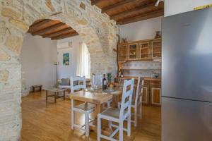 a kitchen with a table and chairs and a refrigerator at SAIL VILLA in Naousa