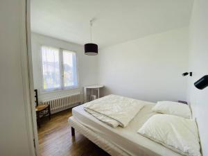 a white bed in a room with a window at Maison Spacieuse à Carnac - 4 Chambres, Terrasse et Jardin, Proche Plage et Commerces - FR-1-377-45 in Carnac