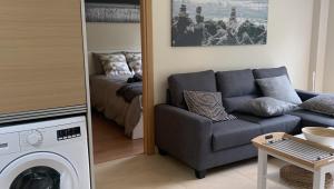 uma sala de estar com um sofá e uma cama em Apartamento Quérote Fisterra1 em Finisterre