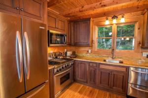 a kitchen with wooden cabinets and a stainless steel refrigerator at Blue Ridge View in Blowing Rock