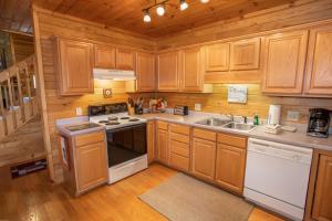 a kitchen with wooden cabinets and a stove and a sink at Boots Off Bungalow in Boone +25 photos