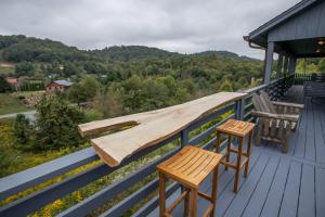una terraza con 2 sillas y una mesa y sillas de madera. en Boots Off Bungalow, en Boone