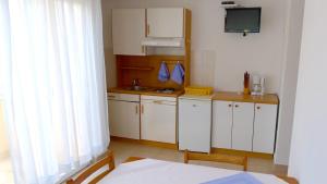 スヴェティ・ペタルにあるApartments Maestralの小さなキッチン(白いキャビネット、テレビ付)