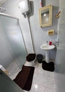 a bathroom with a sink and a toilet and a shower at Apartamento PRATICO in Cascavel