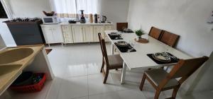 a kitchen with a white table and chairs and a table and chairsktop at Apartamento PRATICO in Cascavel
