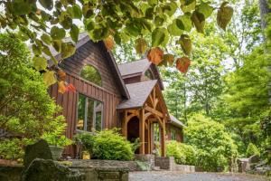 a wooden house in the woods with trees at Chimney Island in Blowing Rock