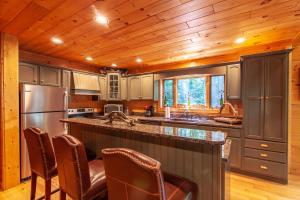 a kitchen with a stainless steel refrigerator and wooden ceilings at Chestnut Falls in Beech Mountain