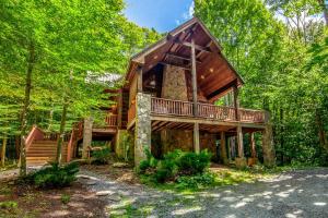 a cabin in the woods with a wrap around deck at Chestnut Falls in Beech Mountain