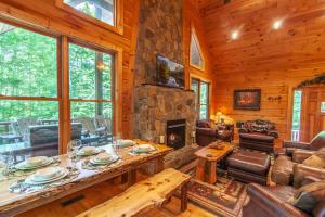 a living room with a table and a fireplace at Chestnut Falls in Beech Mountain