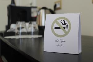 una señal blanca en una mesa con una señal de no fumar en Sant'Agostino - Luxury Rooms, en Messina
