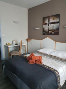 un osito de peluche sentado encima de una cama en Hotel du Centre, en Gueugnon