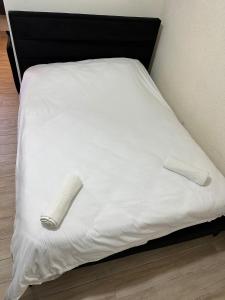 a bed with white sheets and two slippers on it at בר יוחאי in Safed