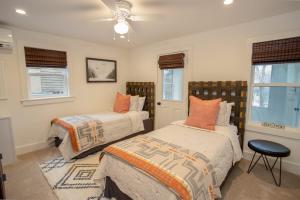 a bedroom with two beds and two windows at Cottage Fever in Blowing Rock