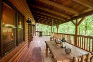 a porch of a cabin with a wooden table and benches at Creek Sound Chalet in Blowing Rock +15 photos