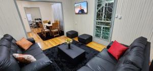 uma sala de estar com um sofá de couro preto e uma mesa em Casa aconchegante e pratica em Cascavel