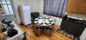 a kitchen with a table with chairs and a refrigerator at Casa aconchegante - compartilhada in Cascavel