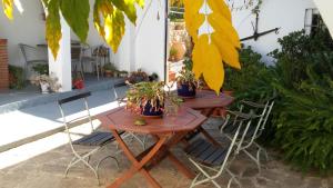 B&B Casa Domingo في ألورا: طاولتين وكراسي خشبتين عليهما نباتات الفخار