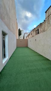 einen leeren Innenhof mit grünem Gras in einem Gebäude in der Unterkunft فيلا قمرية الهدا in Al Hada