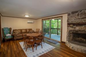 a living room with a table and a fireplace at Fern Cottage in Beech Mountain