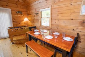 uma sala de jantar com uma mesa de madeira e cadeiras em Eagles Peak em Butler