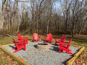 a group of red chairs around a fire pit at Fehrway to Heaven in Blowing Rock