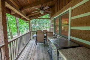 a screened in porch with a kitchen and a stove at Fox Haven in Seven Devils