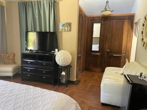 1 dormitorio con cama y vestidor con TV en Bella Noni B&B, en Aguadilla